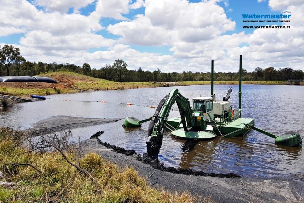 Amphibious Multipurpose Watermaster Recovering coal fines from settling ponds by suction dredging the wet coal ash into dewatering bags, Australia.