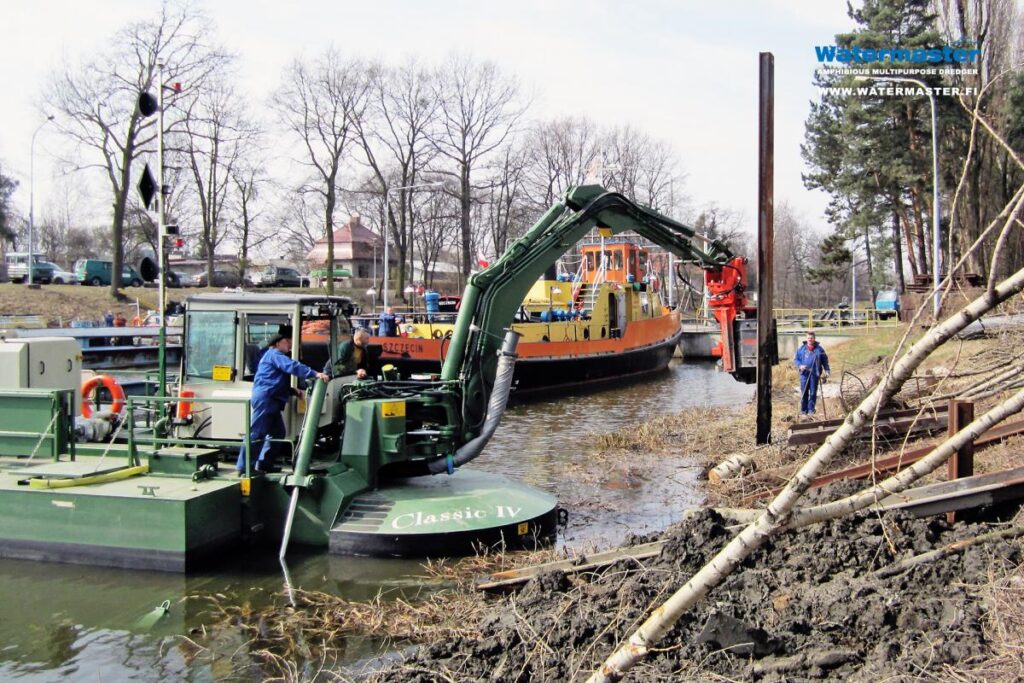 Multipurpose Watermaster Dredger Reinforcing riverbanks by installing sheet pile walls, which help to prevent floods and erosion, Poland
