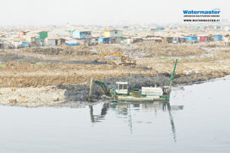 Watermaster cleaning a polluted river in Ghana to prevent floods.