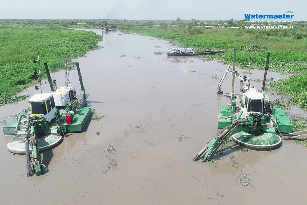 Watermasters dredging a silted channel in Colombia to improve water flow, maintain ecosystems