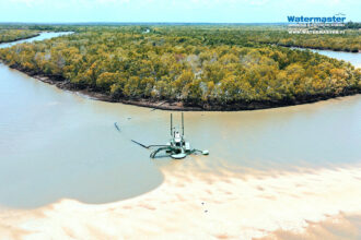 Watermaster dredging the entrance of a channel on the Indian Ocean in Tanzania to enable local fishing boats to enter the port safely