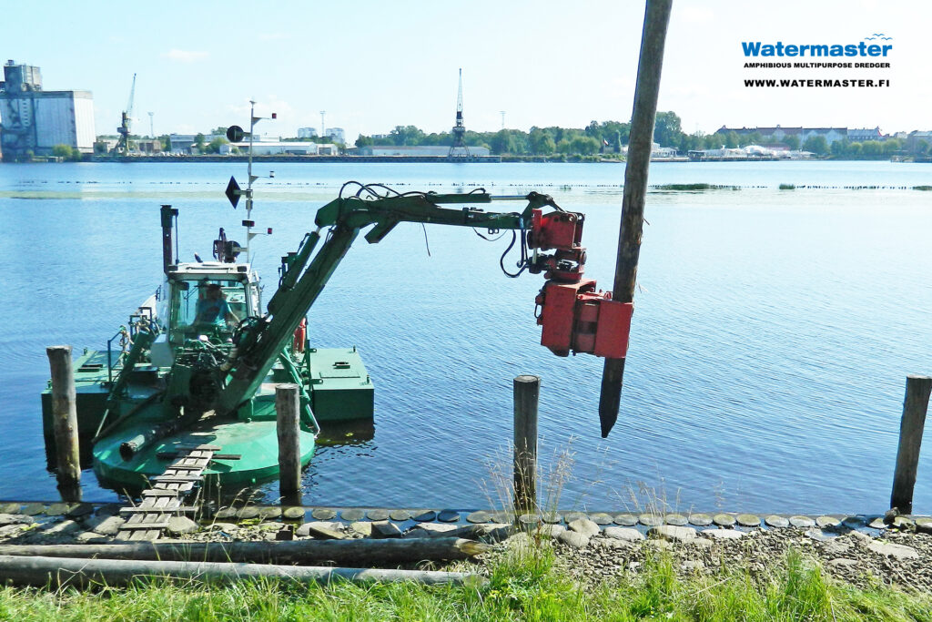 Multipurpose Watermaster Dredger Reinforcing the banks of an urban waterway by pile driving in Lithuania