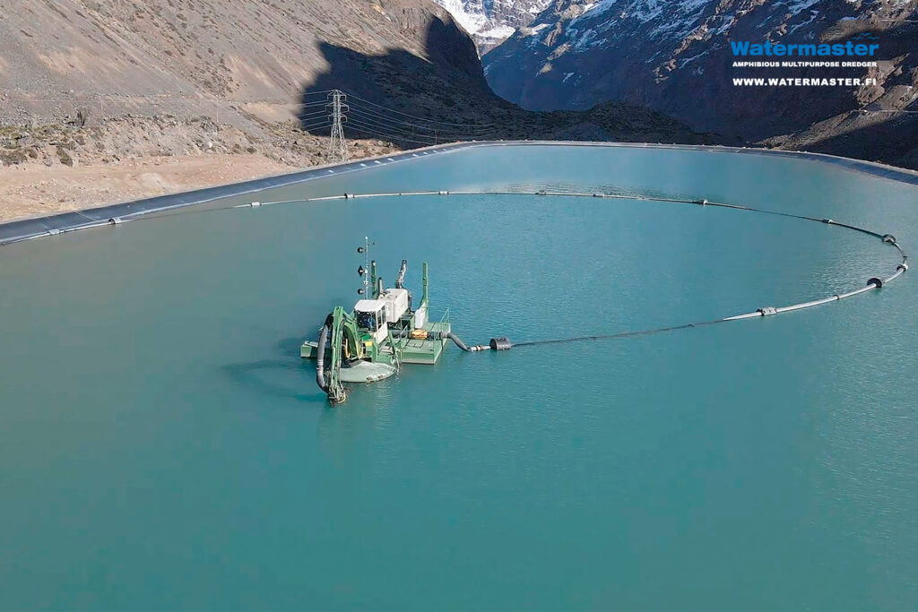 Watermaster cleaning industrial pond in Chile. Dredging out sand from a hydropower facility's water reservoir to restore its storage capacity 